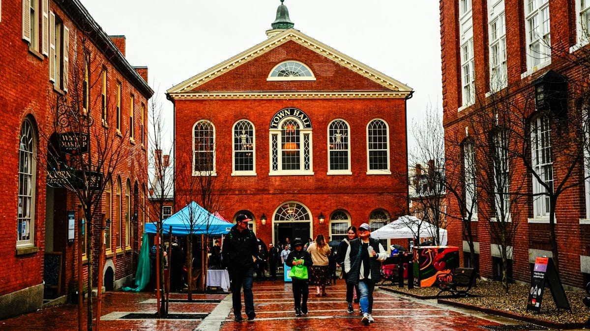 People walking in front of a red brick building