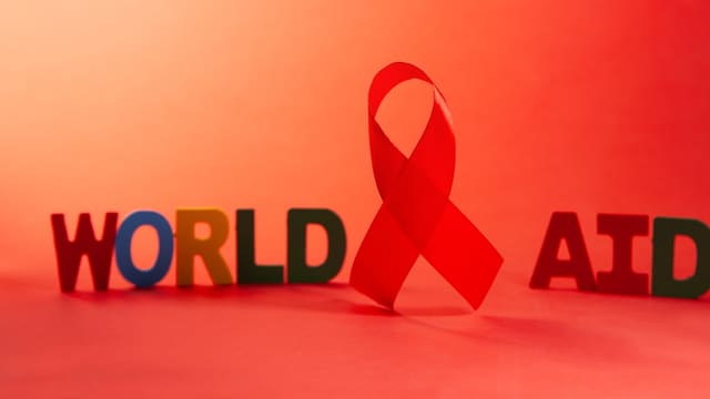 Red ribbon and letters spelling world aids