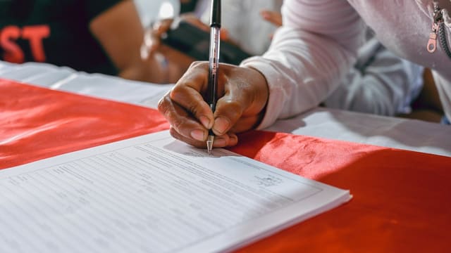 a person writing on a piece of paper