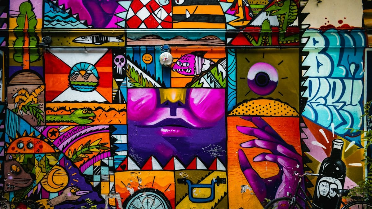 Une fresque de street art colorée recouvre entièrement un mur, dans l'esprit des œuvres peintes lors du festival.