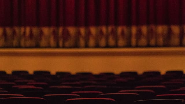 Rangées de fauteuils rouges vides dans une salle de spectacle