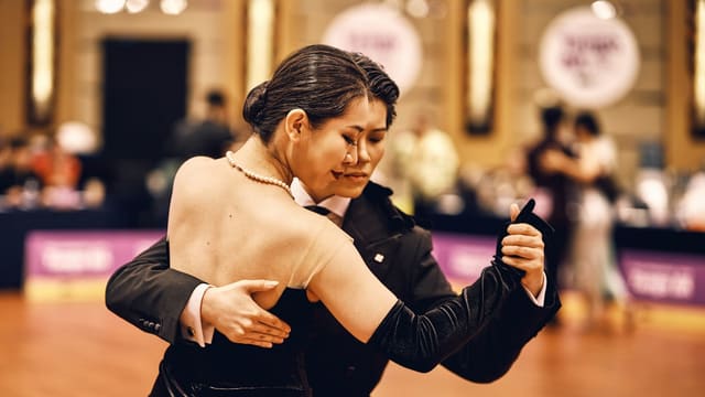 A couple dances ballroom at a competition event.