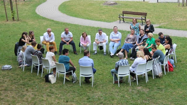 circle of people sitting on chair on grass fiedl