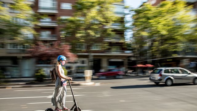 girl in pink dress riding kick scooter on road during daytime