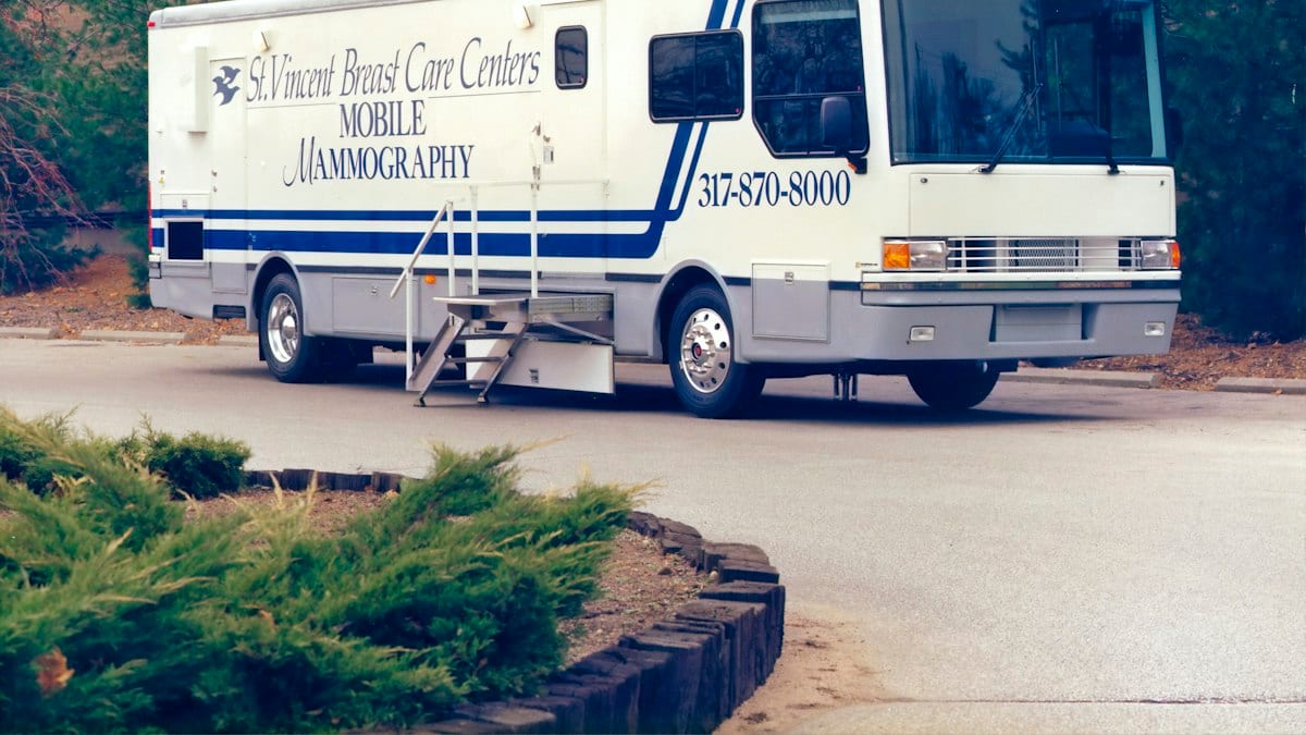 white and blue rv trailer parked on gray asphalt road during daytime