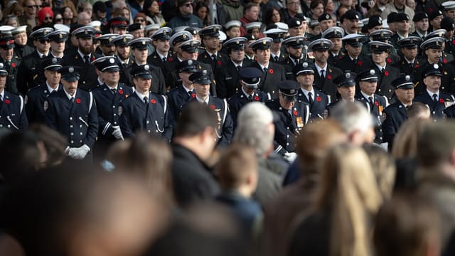 A group of firefighters in uniform standing at attention