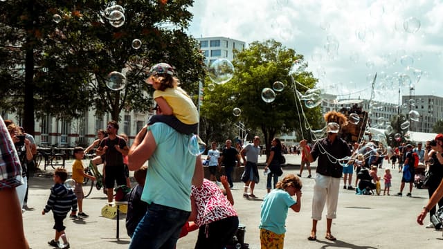 a group of people are playing with soap bubbles