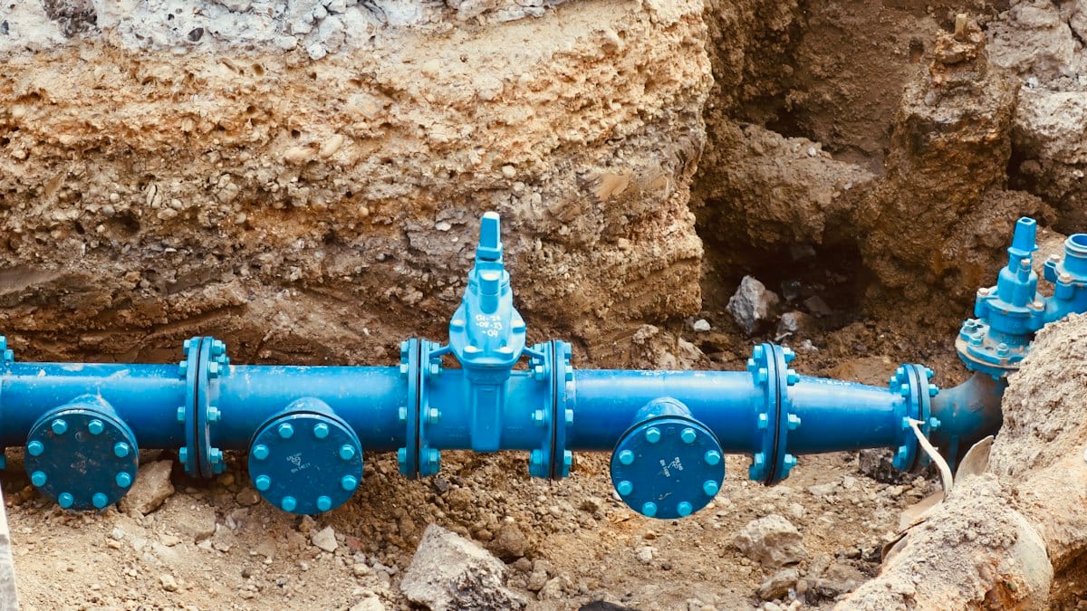 a blue pipe laying on top of a pile of dirt