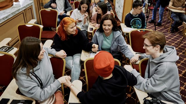 a group of people sitting around a table in a room