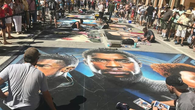 Homme en t-shirt col rond blanc debout à côté d'une femme en débardeur noir